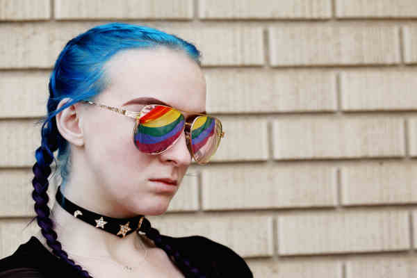 青い髪と虹色のサングラスをかけた女性