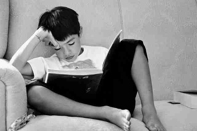 ソファで本を読む男の子