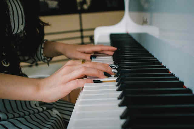 きれいなマニキュアを塗ってピアノ演奏をする女性