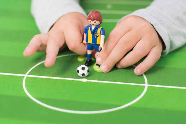 サッカーのおもちゃで遊ぶ子供の手